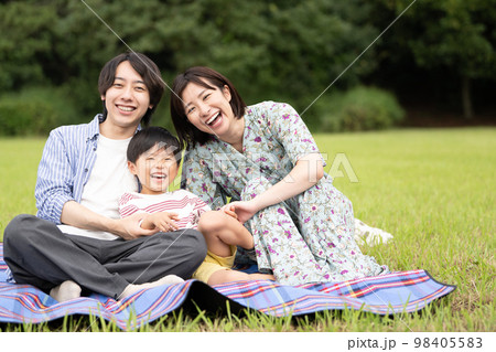 公園でレジャーシートに座るファミリーイメージ 98405583