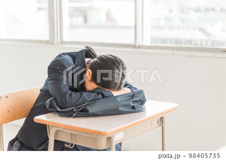 学校の教室で悩む・泣く高校生・中学生の女の子（疲労・いじめ・頭痛・腹痛・生理痛・眠い） 98405735