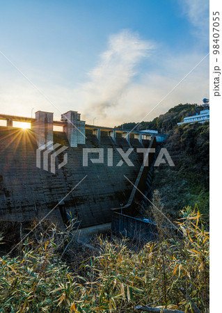 奈良布目ダムの夕景　布目ダム全景　水路になっている格子窓から綺麗な光芒を放つ夕日③ 98407055