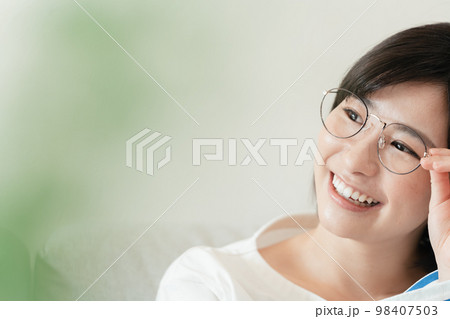 リビングでメガネをかける若い女性 98407503