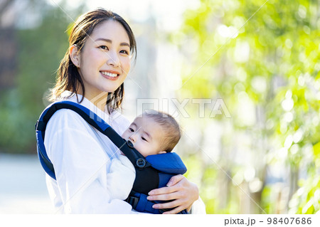 抱っこ紐で育児をする若い女性 98407686