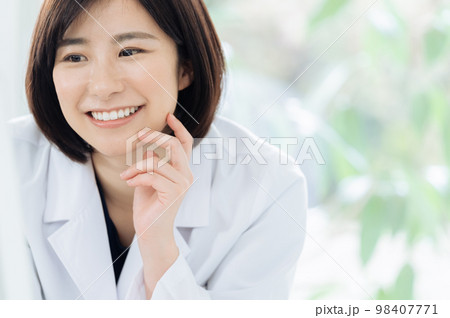 優しく微笑む白衣姿の女性 優しく微笑む白衣姿の女性 98407771