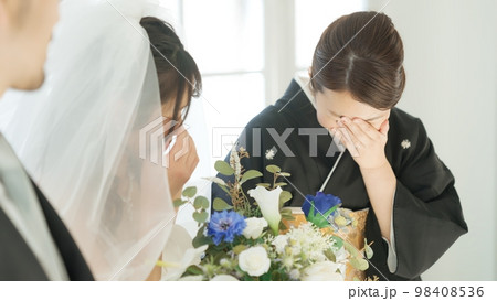 娘の結婚に嬉し泣きする親 98408536
