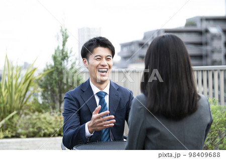 休憩中に話をするビジネスマン 98409688