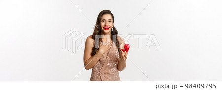 Image of beautiful woman in glamour dress receiving engagement ring, looking surprised and happy at camera, being proposed, standing over white background Image of beautiful woman in glamour dress receiving engagement ring, looking surprised and happy at camera, being proposed, standing over white background 98409795