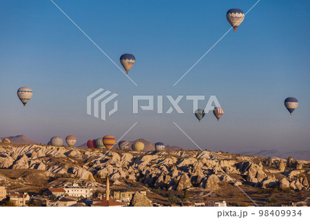Cappadocia. View of Goreme town with caves and hot air balloons in Cappadocia. Turkey. Cappadocia. View of Goreme town with caves and hot air balloons in Cappadocia. Turkey. 98409934