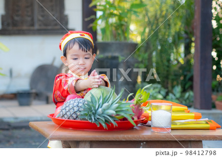 Asian baby boy with traditional Chinese outfit. prepare fruit for offerings Chinese God. 98412798