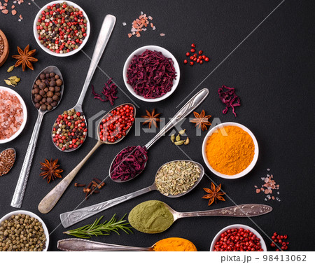 Composition consisting of variations of spices in white bowls and metal spoons 98413062