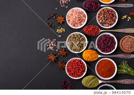 Composition consisting of variations of spices in white bowls and metal spoons Composition consisting of variations of spices in white bowls and metal spoons 98413070
