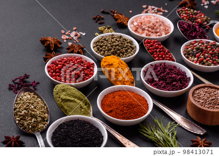 Composition consisting of variations of spices in white bowls and metal spoons Composition consisting of variations of spices in white bowls and metal spoons 98413071