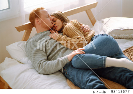 Couple in love relaxing at home on bed while they hug each other. Valentine's Day, holiday concept. Couple in love relaxing at home on bed while they hug each other. Valentine's Day, holiday concept. 98413677