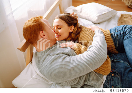 Couple in love relaxing at home on bed while they hug each other. Valentine's Day, holiday concept. Couple in love relaxing at home on bed while they hug each other. Valentine's Day, holiday concept. 98413679