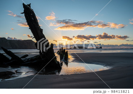 Wreck of the Helvetia, shipwreck on Rhossili beach at sunset, no people. Gower Peninsula, South Wales, the United Kingdom, UK GB. Wreck of the Helvetia, shipwreck on Rhossili beach at sunset, no people. Gower Peninsula, South Wales, the United Kingdom, UK GB. 98413821