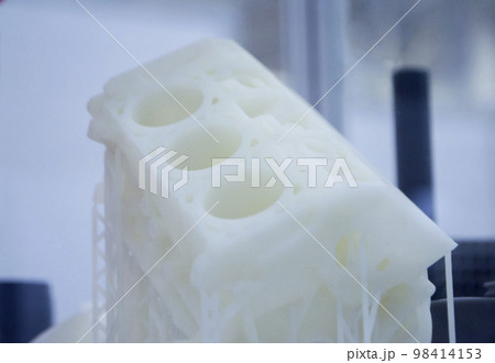 Object printed on 3D printer from plastic. The object a prototype of an automobile engine printed on a 3D printer from white plastic. 3D volumetric model. Concept new modern printing technology Object printed on 3D printer from plastic. The object a prototype of an automobile engine printed on a 3D printer from white plastic. 3D volumetric model. Concept new modern printing technology 98414153