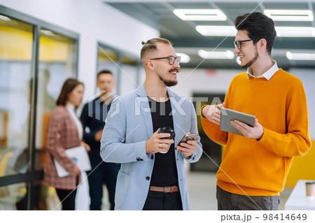 Colleagues with coffee are discussing a new business project in creative office. Planning, study. 98414649