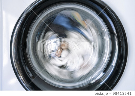 Washing machine with clothes in interior of the laundry room at home. Housework and cleaning concept. Washing machine with clothes in interior of the laundry room at home. Housework and cleaning concept. 98415541