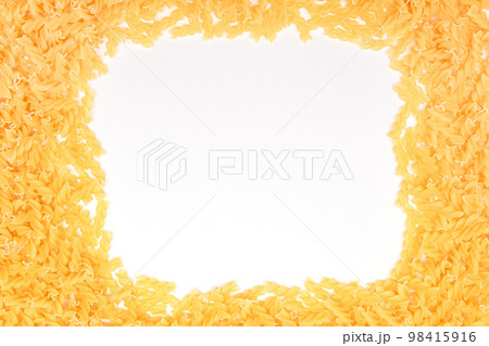 A Frame Made from Uncooked Fusilli Pasta Scattered on White Table 98415916