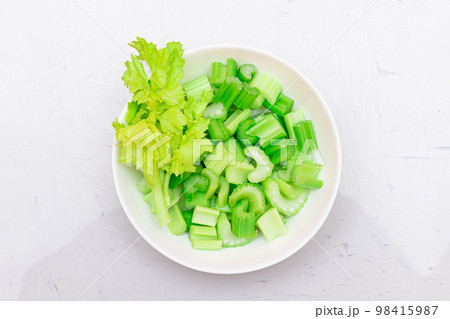 Fresh Chopped Celery Slices with Water Drops on White Dish - Top View 98415987
