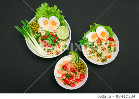 Noodle Dish with Green Onions, Eggs, Green Pea, Red Hot Pepper, Greens and Lime Noodle Dish with Green Onions, Eggs, Green Pea, Red Hot Pepper, Greens and Lime 98417534