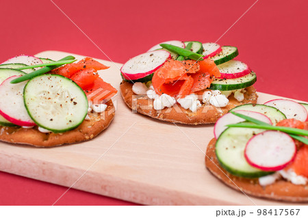 Cracker Sandwiches with Salmon, Cucumber, Radish, Cottage Cheese and Green Onions 98417567