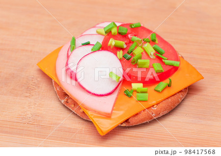 Crispy Cracker Sandwich with Tomato, Sausage, Cheese, Green Onions and Radish 98417568