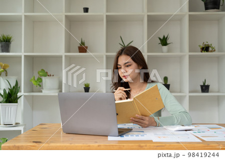 Concentrated female student busy studying using laptop make notes in notebook, focused man worker employee write watching webinar or online training course on computer, education concept 98419244