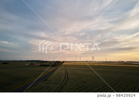 Aerial view of windmill turbine generator against beautiful sunset sky in countryside area, Concept of clean, renewable, sustainable, alternative energy Aerial view of windmill turbine generator against beautiful sunset sky in countryside area, Concept of clean, renewable, sustainable, alternative energy 98420924