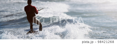 Athletic man jumping on kite surf board on a sea waves. Kiteboarding man among waves quickly goes. Watersport adrenaline fun adventure acitivity 98421268