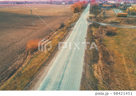 Aerial view of countryside and straight country road. Farmland in autumn Aerial view of countryside and straight country road. Farmland in autumn 98421451