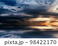 Beautiful sunset over the sea, background, with reflection in the water, majestic formidable clouds in the sky. 98422170