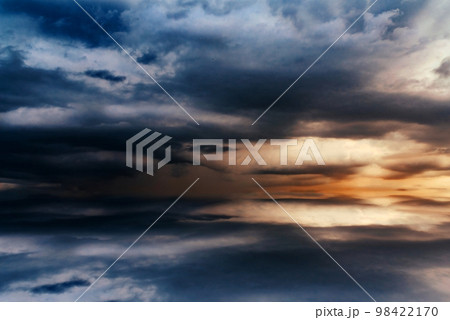 Beautiful sunset over the sea, background, with reflection in the water, majestic formidable clouds in the sky. 98422170