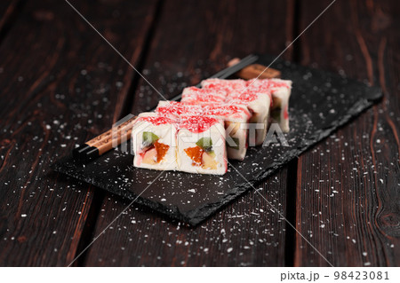 Asian sweet dessert maki sushi - Roll with fruits and cream cheese with coconut flakes and topping Asian sweet dessert maki sushi - Roll with fruits and cream cheese with coconut flakes and topping 98423081