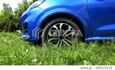 Front Car Wheel Stay On A Crumpled Green Grass Front Car Wheel Stay On A Crumpled Green Grass 98423418