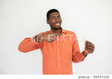 Portrait of happy young man pointing at credit card 98424100