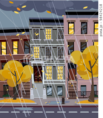 Flat cartoon vector illustration of autumn rainy city street at night. 3-4-story uneven houses with luminous windows,. Street cityscape. Evening town landscape with trees in the foreground, puddles 98424218