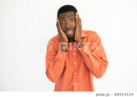 Portrait of amazed young man holding face in hands 98424334