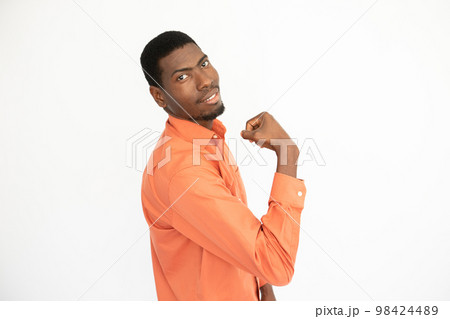 Portrait of happy young man showing bicep and smiling 98424489