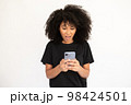 Portrait of excited young woman reading message on smartphone 98424501