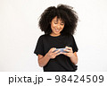 Portrait of happy young woman playing game on mobile phone 98424509