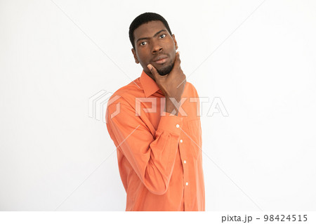 Portrait of confident young man touching chin Portrait of confident young man touching chin 98424515
