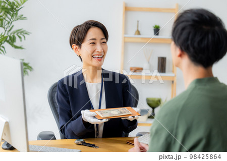 腕時計を査定する女性　 98425864