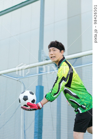 サッカーボールをキャッチするゴールキーパーの男性 98426501