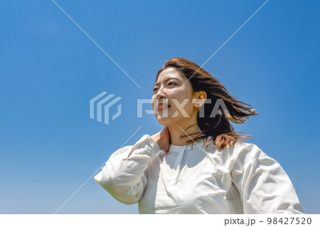 青空バックの若い女性 98427520