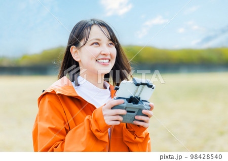 ドローンを操縦する若い女性 ドローンを操縦する若い女性 98428540