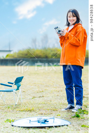 ドローンを操縦する若い女性 98428638