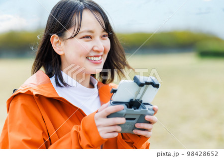 ドローンを操縦する若い女性 ドローンを操縦する若い女性 98428652