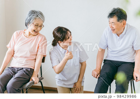 介護施設で椅子体操・運動・リハビリするシニア・高齢者の男女と理学療法士・介護士・トレーナー 98429986