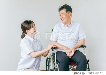 シニア・高齢者男性と話す介護士・看護師・理学療法士・ヘルパーのアジア人女性 98430843