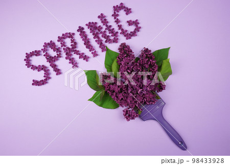 The word SPRING is written with a brush with lilac flowers. 98433928