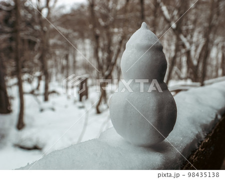 【冬】デッキの手すりの上の小さな雪だるま 98435138